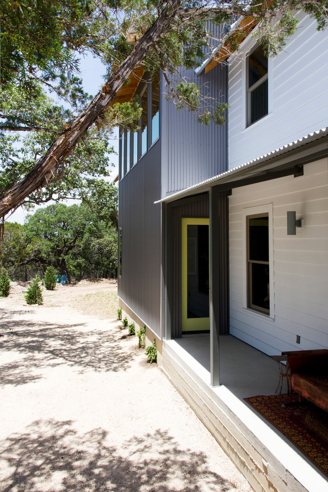Zweistöckiges Landhausstil Haus mit Mix-Fassade und weißer Fassadenfarbe in Austin
