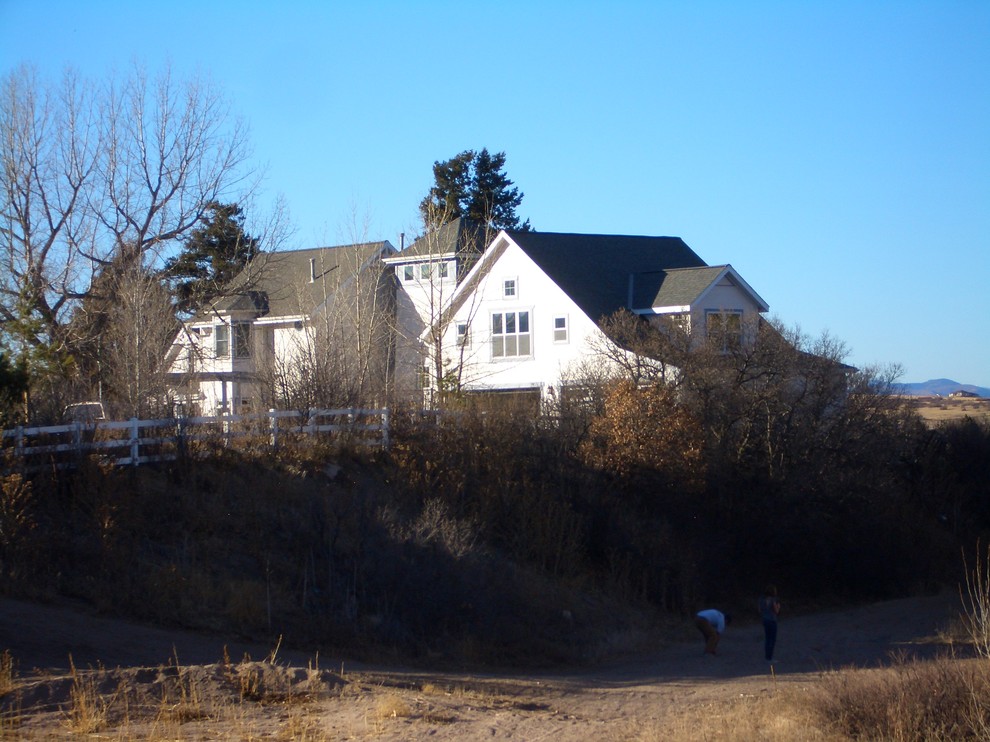 Imagen de fachada blanca de estilo de casa de campo grande de dos plantas con revestimiento de madera y tejado a dos aguas