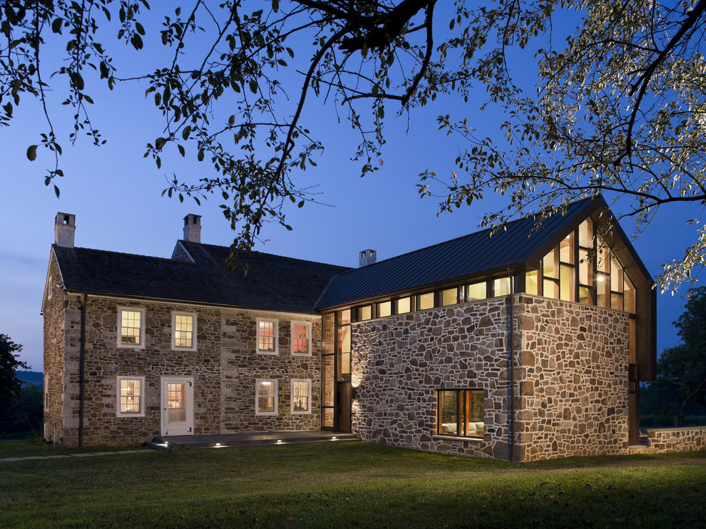 Brown contemporary two floor house exterior in Philadelphia with stone cladding and a pitched roof.