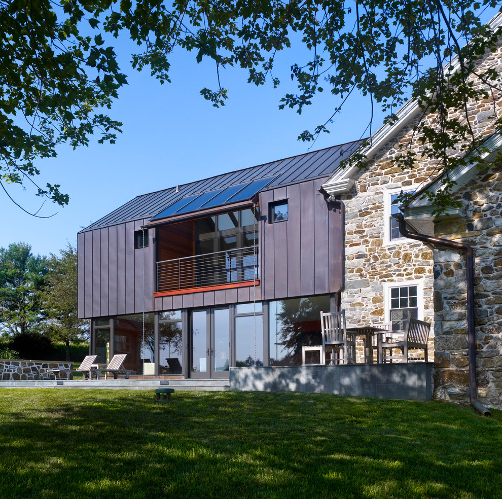 Стильный дизайн: двухэтажный, бежевый дом среднего размера в современном стиле с облицовкой из камня и двускатной крышей - последний тренд