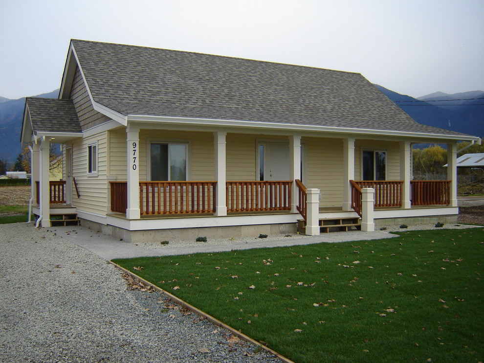 Foto della villa piccola gialla country a un piano con rivestimento in vinile, tetto a capanna e copertura a scandole
