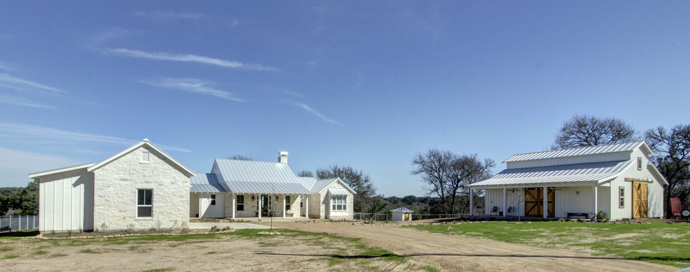 Photo of a large and beige rural bungalow detached house in Austin with stone cladding and a metal roof.