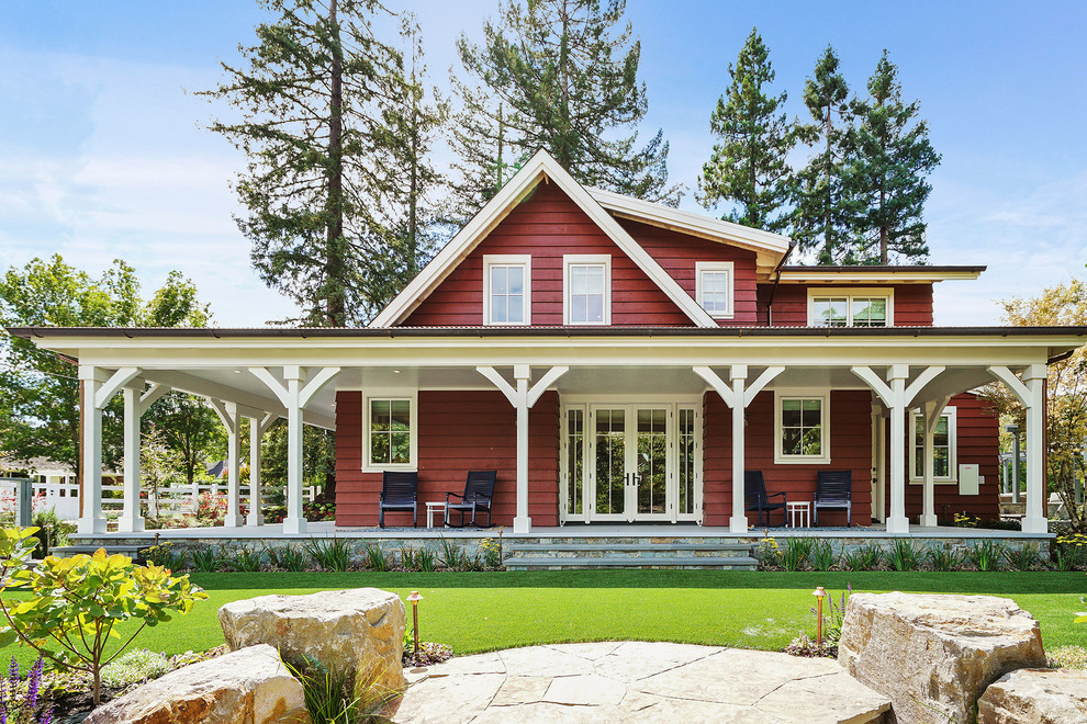 Cette photo montre une grande façade de maison rouge nature en bois à un étage.