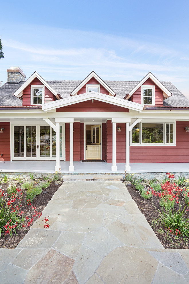 This is an example of a large and red country two floor house exterior in San Francisco with wood cladding, a pitched roof and a mixed material roof.