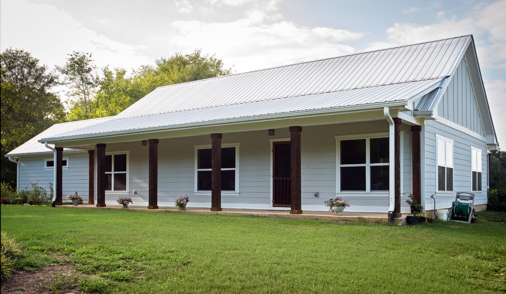 Ejemplo de fachada gris de estilo de casa de campo de tamaño medio de una planta con revestimiento de aglomerado de cemento y tejado a dos aguas