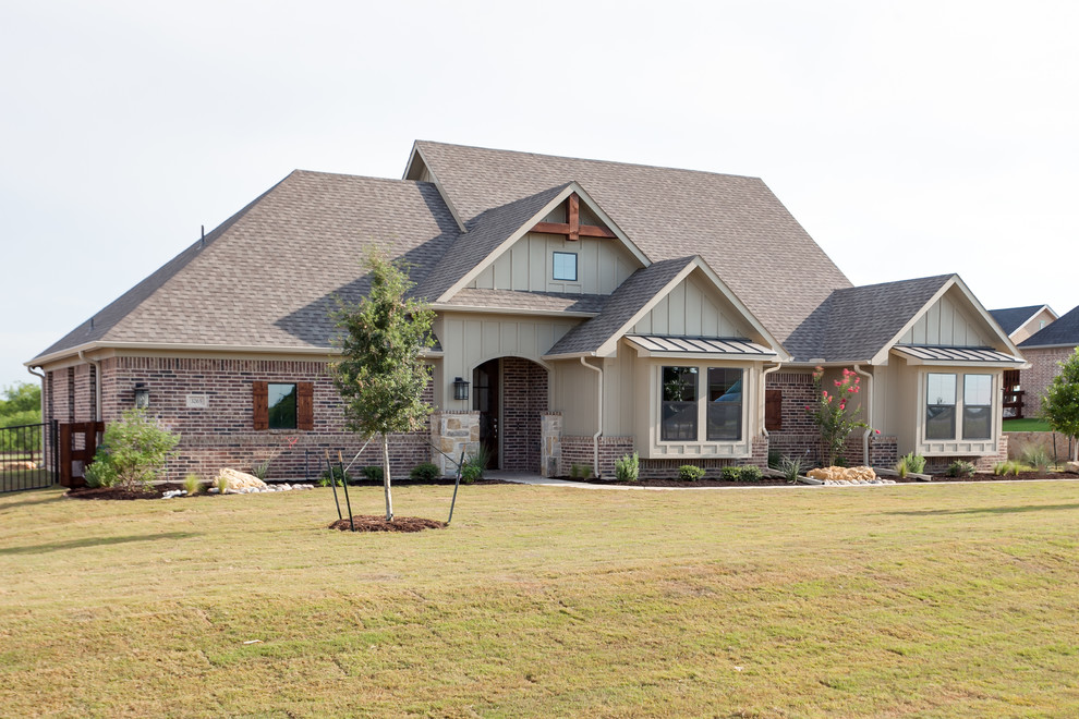 This is an example of a large and red country two floor brick detached house in Dallas with a half-hip roof and a shingle roof.