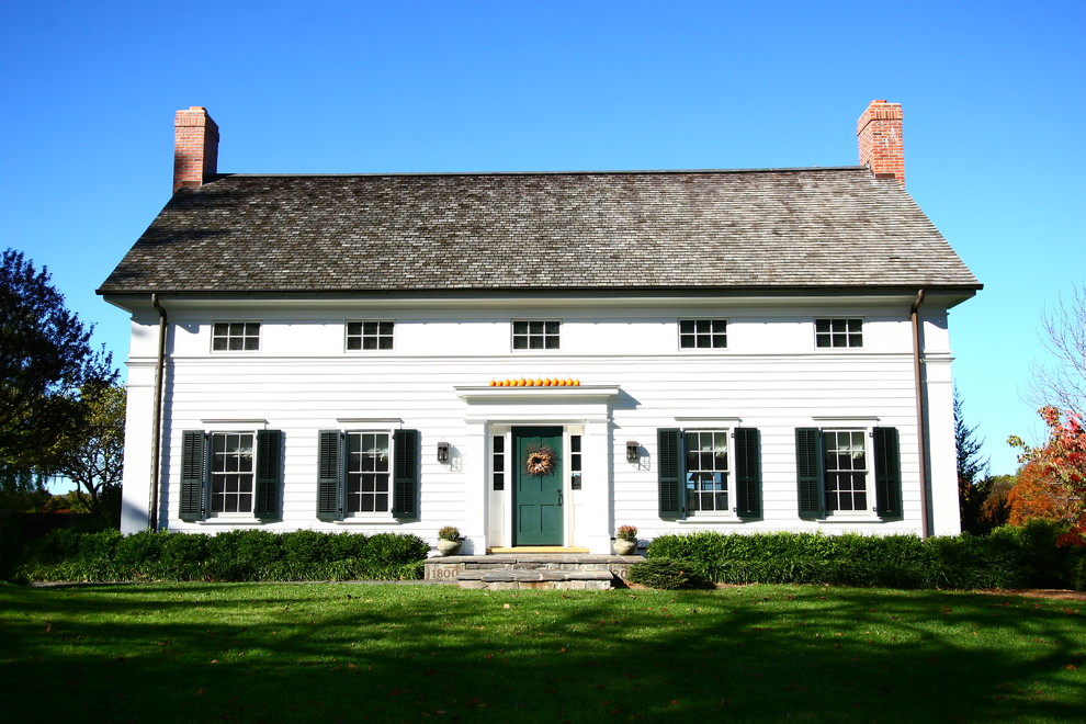 White rural two floor house exterior in New York with wood cladding.