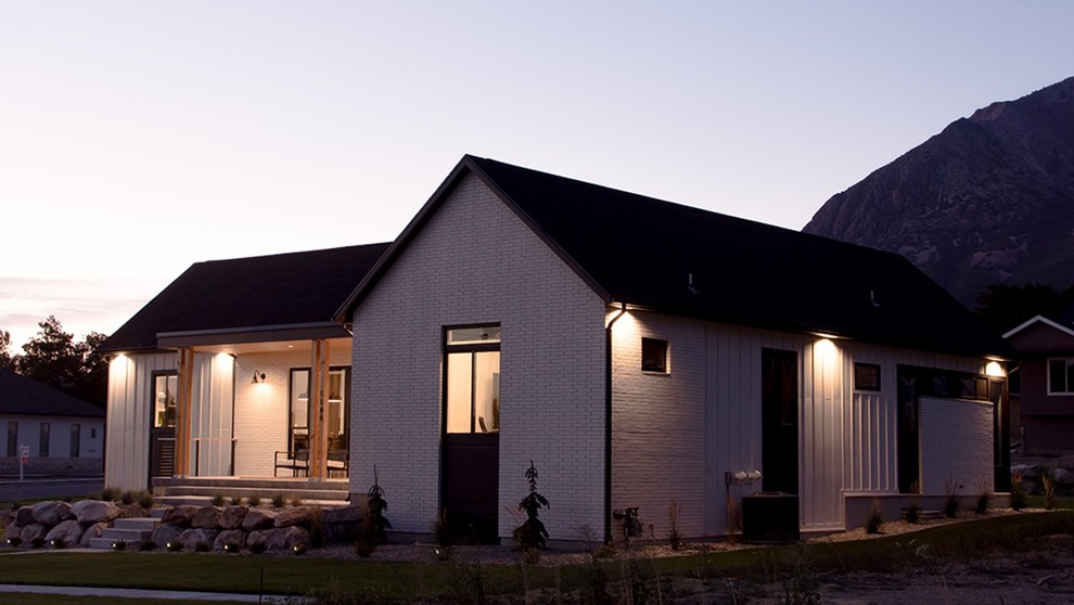 Imagen de fachada de casa blanca de estilo de casa de campo de tamaño medio de dos plantas con revestimientos combinados, tejado a dos aguas y tejado de varios materiales