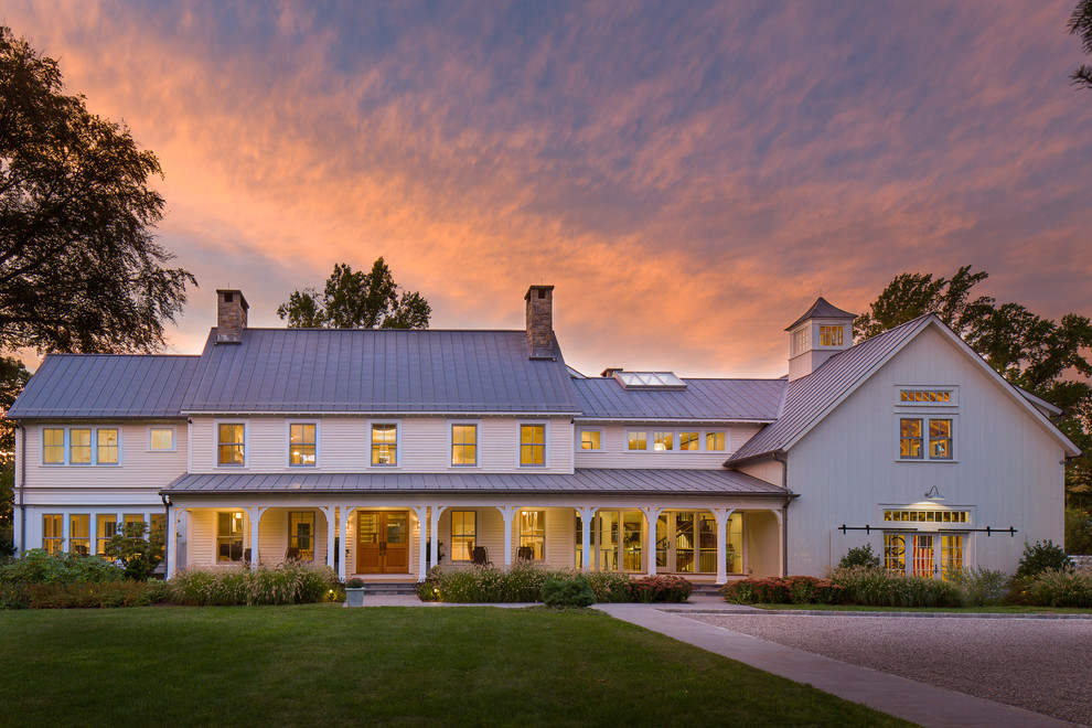 Example of a large farmhouse white two-story gable roof design in New York