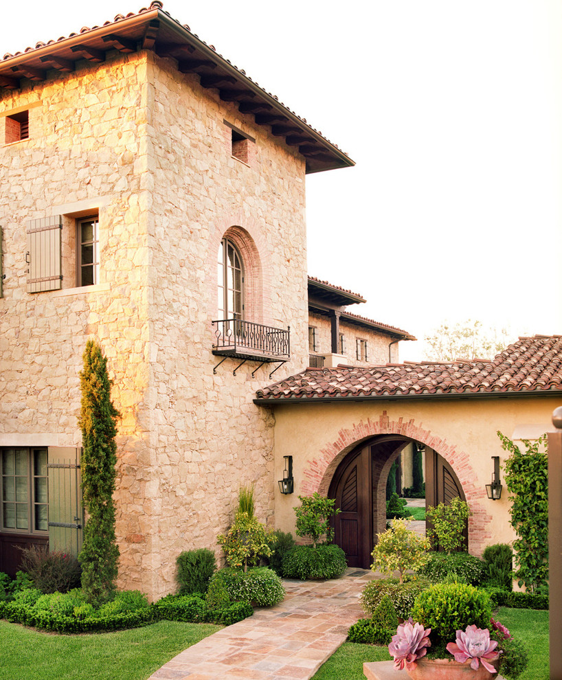This is an example of a mediterranean house exterior in Los Angeles with three floors and stone cladding.