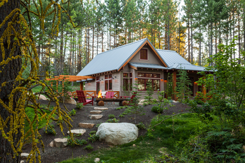 Idée de décoration pour une façade de maison grise chalet en bois de taille moyenne et de plain-pied avec un toit à deux pans.