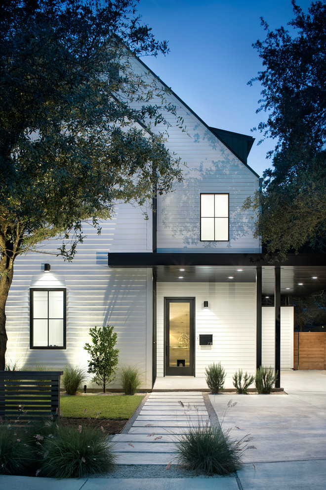 Aménagement d'une grande façade de maison blanche campagne en bois à un étage avec un toit à deux pans et un toit mixte.