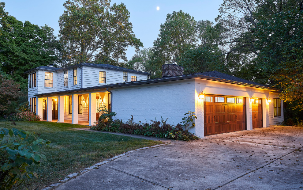 Mittelgroßes, Zweistöckiges Landhaus Einfamilienhaus mit gestrichenen Ziegeln, weißer Fassadenfarbe, Walmdach, Schindeldach und grauem Dach in Cincinnati