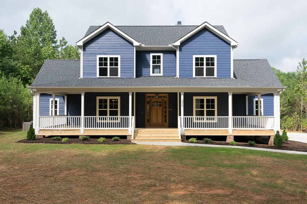 Exemple d'une façade de maison bleue nature de taille moyenne et à un étage avec un revêtement en vinyle, un toit à deux pans et un toit en shingle.