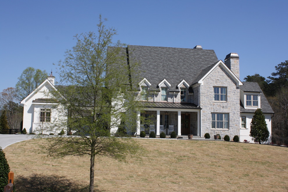 Réalisation d'une grande façade de maison multicolore champêtre à un étage avec un revêtement mixte, un toit à deux pans et un toit en shingle.