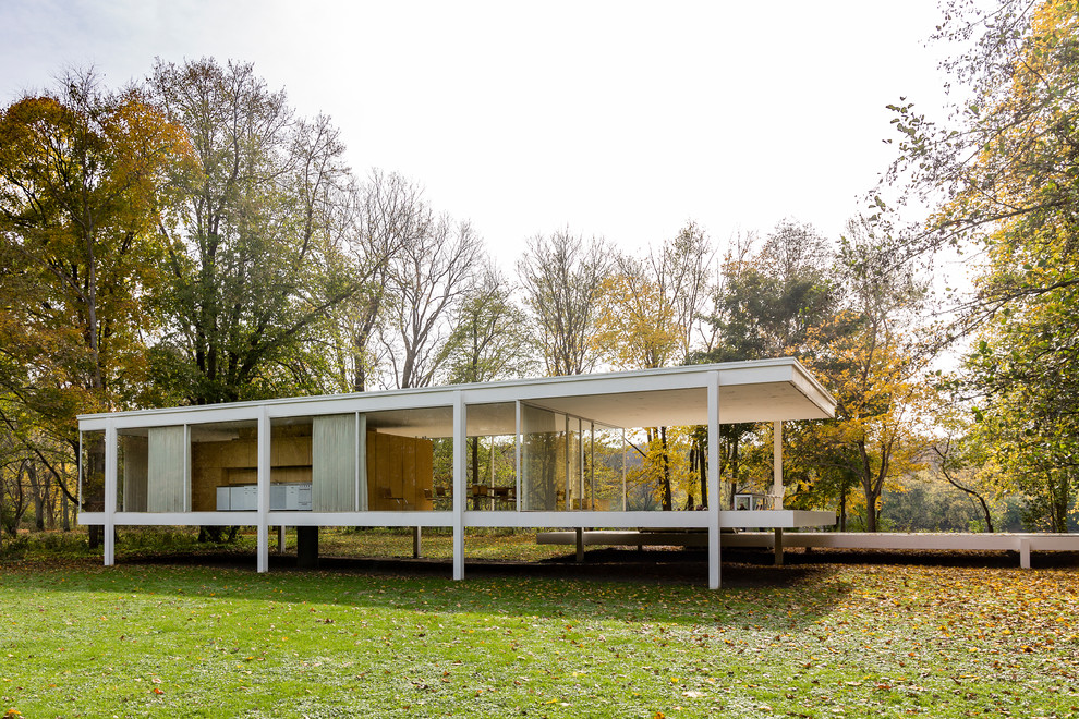Photo of a white modern bungalow glass house exterior in Other with a flat roof.