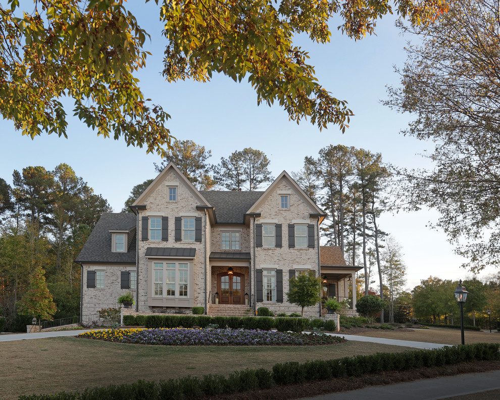 Large traditional beige two-story brick gable roof idea in Atlanta
