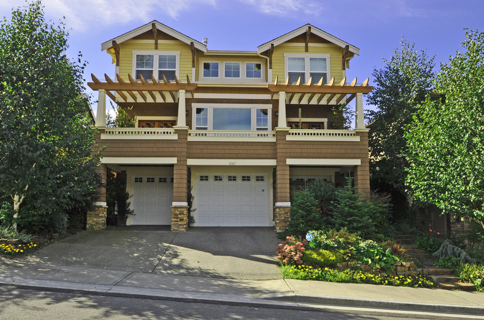 Example of a classic yellow three-story wood exterior home design in Seattle