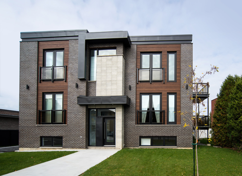 Exemple d'une grande façade de maison multicolore tendance à deux étages et plus avec un revêtement mixte et un toit plat.