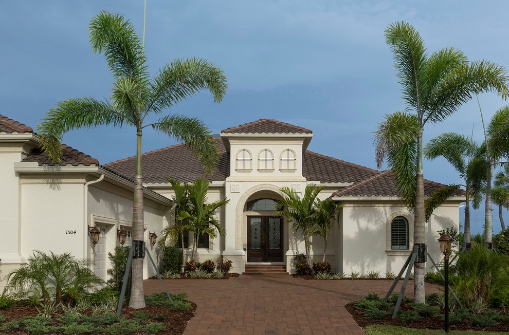Inspiration for a large mediterranean beige one-story stucco exterior home remodel in Tampa with a hip roof