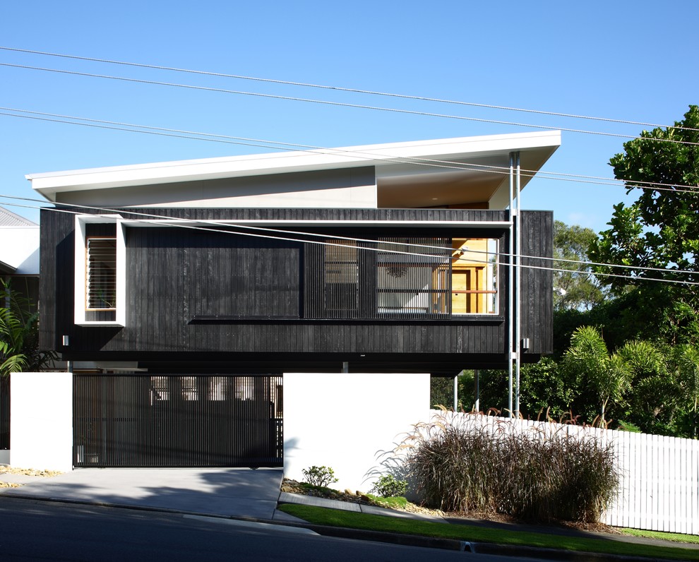 Zweistöckige, Mittelgroße Moderne Holzfassade Haus mit schwarzer Fassadenfarbe und Pultdach in Brisbane