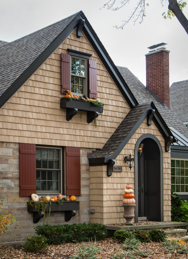Ejemplo de fachada de casa beige clásica pequeña de dos plantas con revestimiento de ladrillo, tejado a dos aguas y tejado de teja de madera