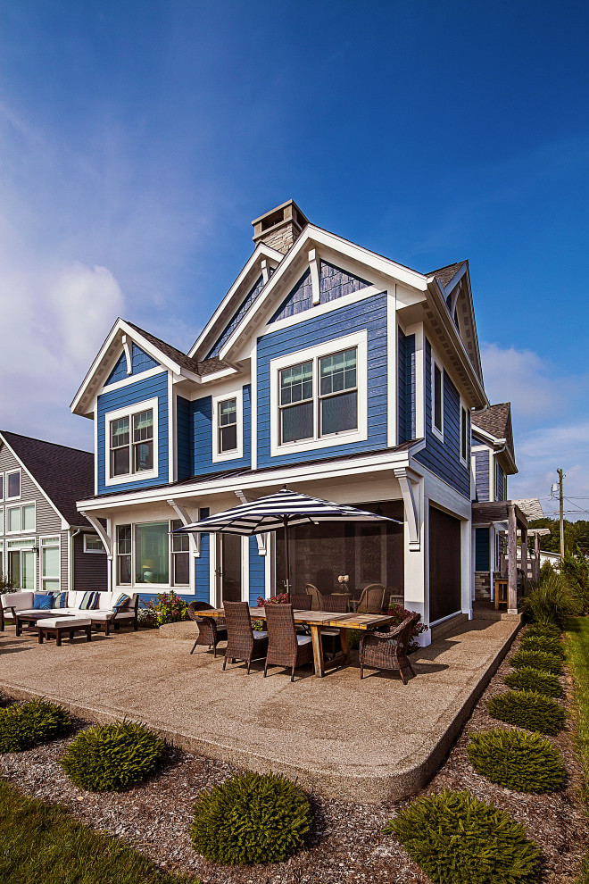 Ejemplo de fachada de casa azul marinera pequeña de dos plantas con revestimiento de aglomerado de cemento, tejado a dos aguas y tejado de teja de madera