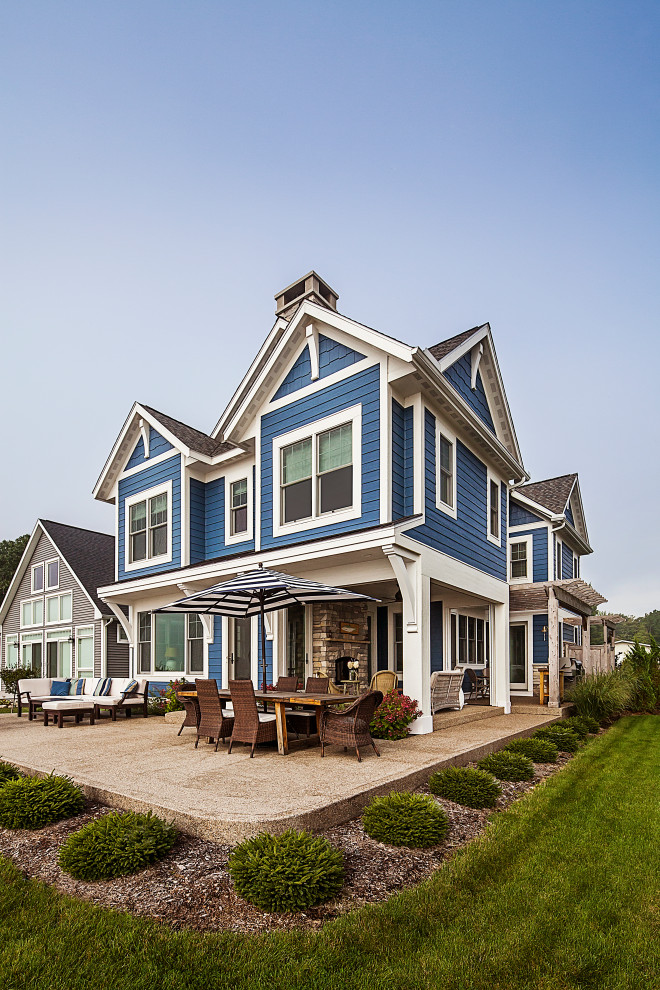 Idee per la villa piccola blu stile marinaro a due piani con rivestimento con lastre in cemento, tetto a capanna e copertura a scandole