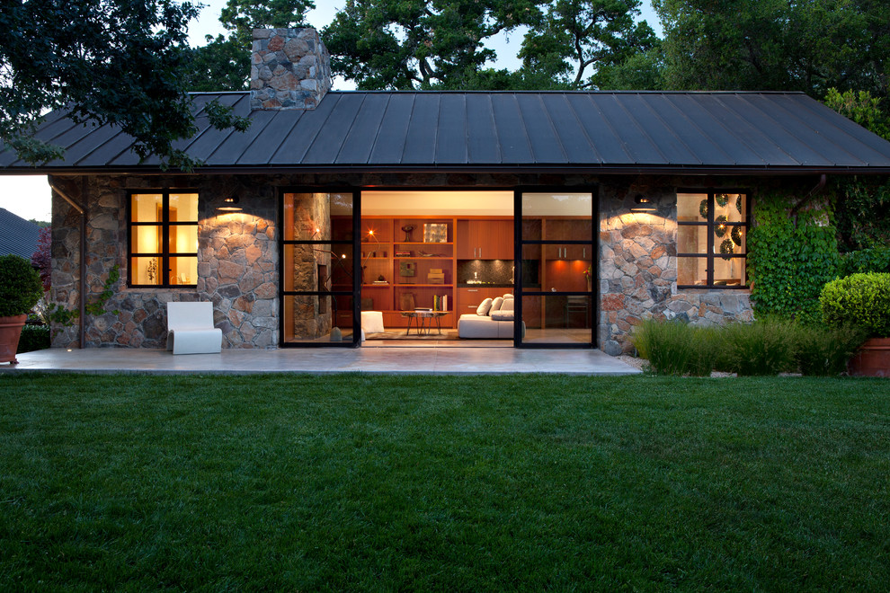 Inspiration pour une façade de maison grise design en pierre de plain-pied et de taille moyenne avec un toit à deux pans.
