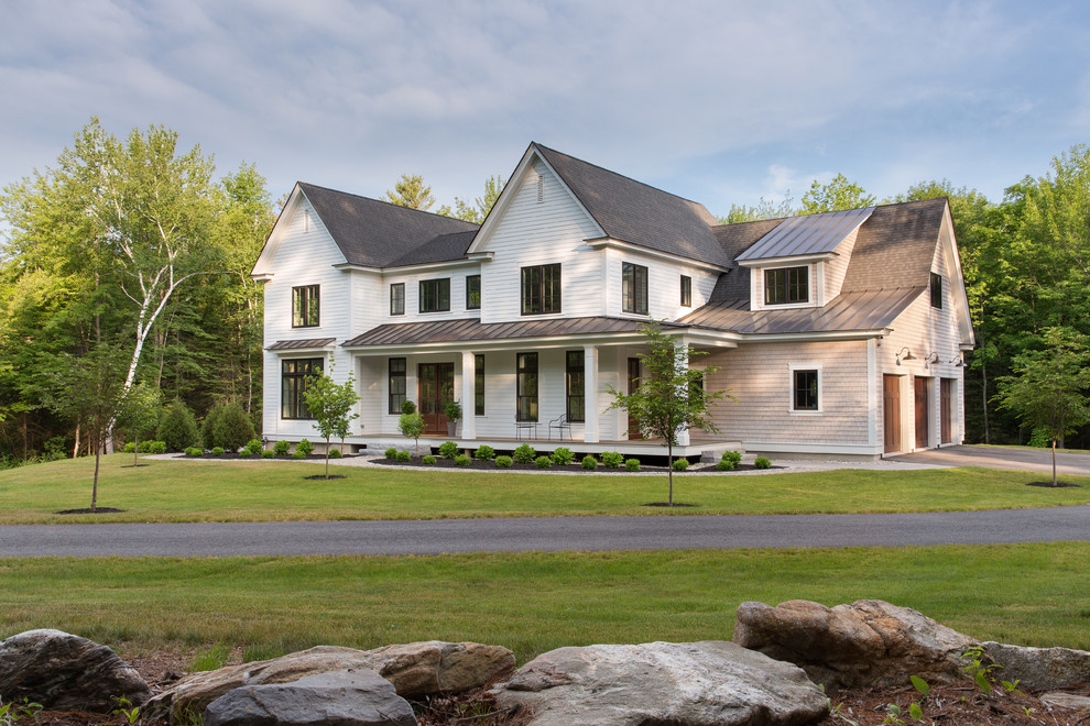 Cette image montre une grande façade de maison blanche rustique à un étage avec un revêtement mixte et un toit à deux pans.