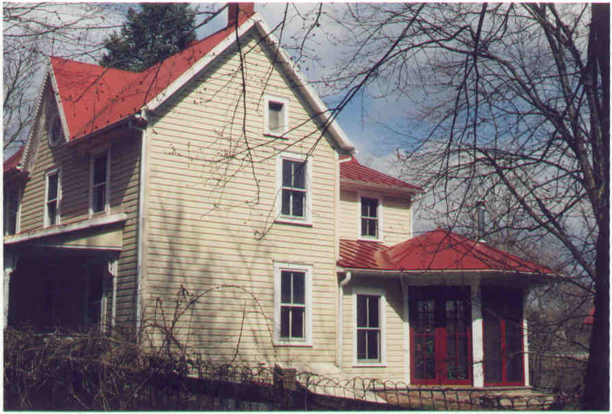 Diseño de fachada de casa amarilla tradicional de tamaño medio de dos plantas con revestimiento de madera