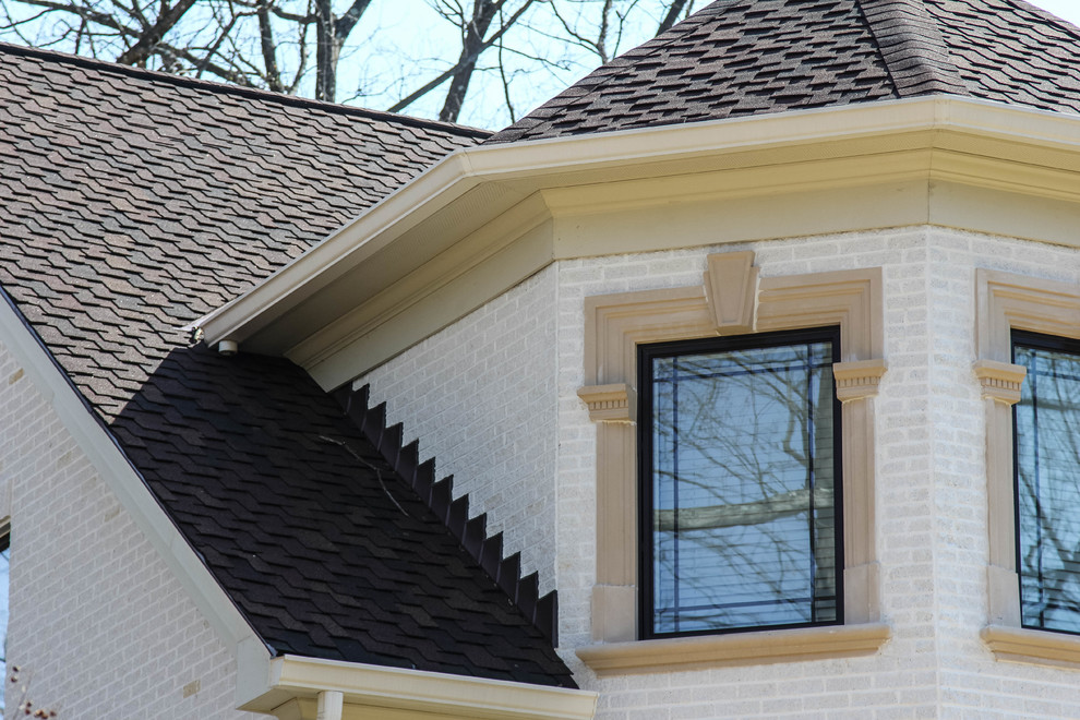 Ejemplo de fachada de casa blanca clásica de tamaño medio de dos plantas con revestimiento de ladrillo, tejado a dos aguas y tejado de teja de madera