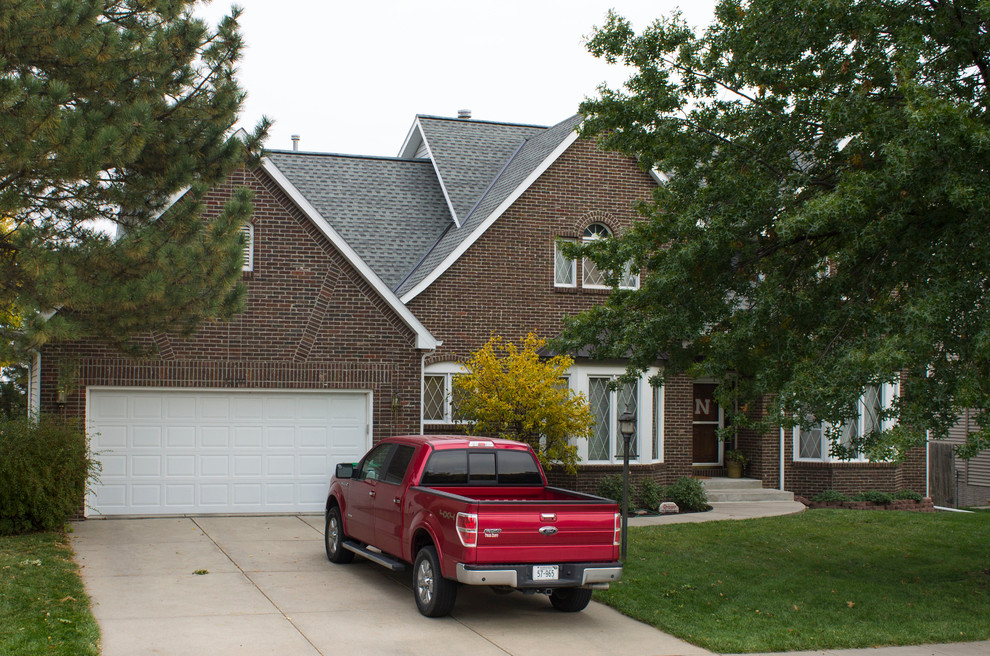 Inspiration for a mid-sized timeless red two-story brick gable roof remodel in Omaha