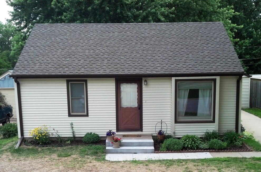 Immagine della facciata di una casa piccola beige classica a un piano con tetto a capanna