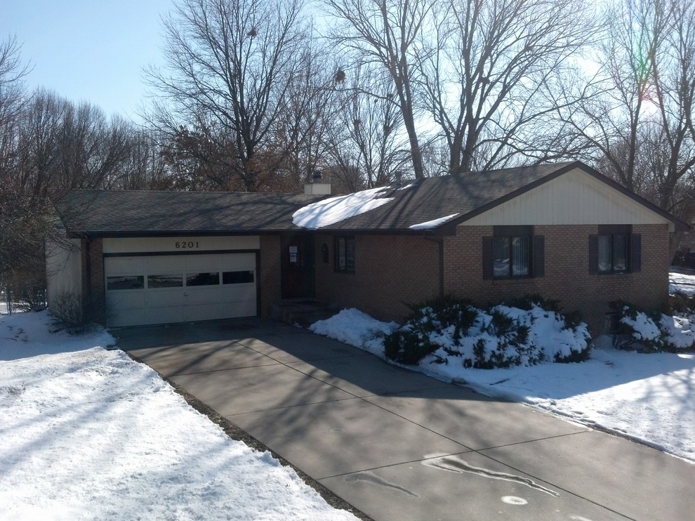 Medium sized and brown traditional bungalow house exterior in Omaha with a pitched roof.