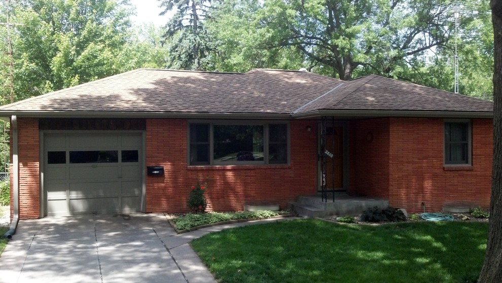 Exemple d'une petite façade de maison rouge chic en brique de plain-pied avec un toit à quatre pans.