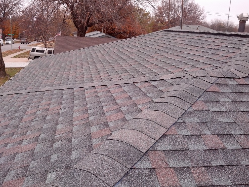 Example of a small red one-story brick exterior home design in Omaha with a hip roof