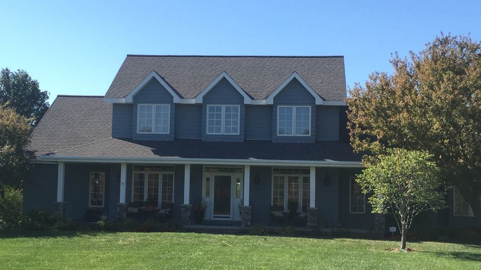Inspiration for a large timeless gray two-story vinyl exterior home remodel in Omaha with a tile roof