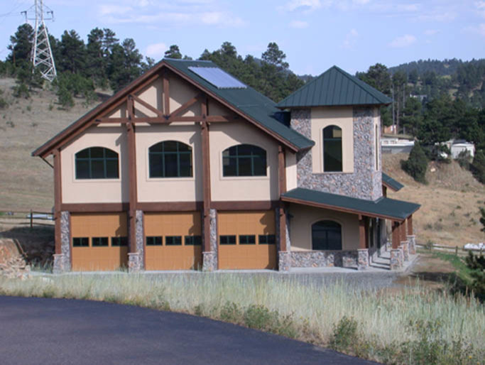 Cette image montre une grande façade de maison marron chalet à deux étages et plus avec un revêtement mixte, un toit à quatre pans et un toit en métal.