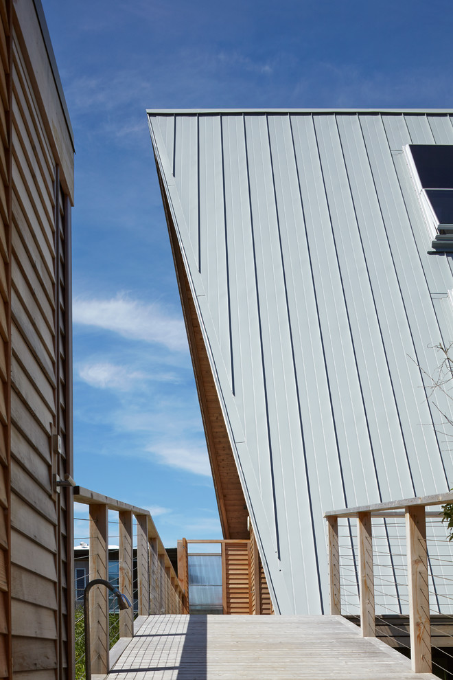 Imagen de fachada de casa marrón contemporánea pequeña de tres plantas con revestimiento de madera, tejado a dos aguas y tejado de metal