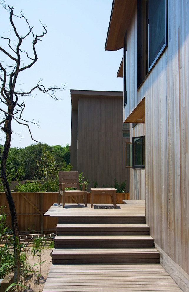 Aménagement d'une façade de maison marron contemporaine en bois à un étage avec un toit en appentis.