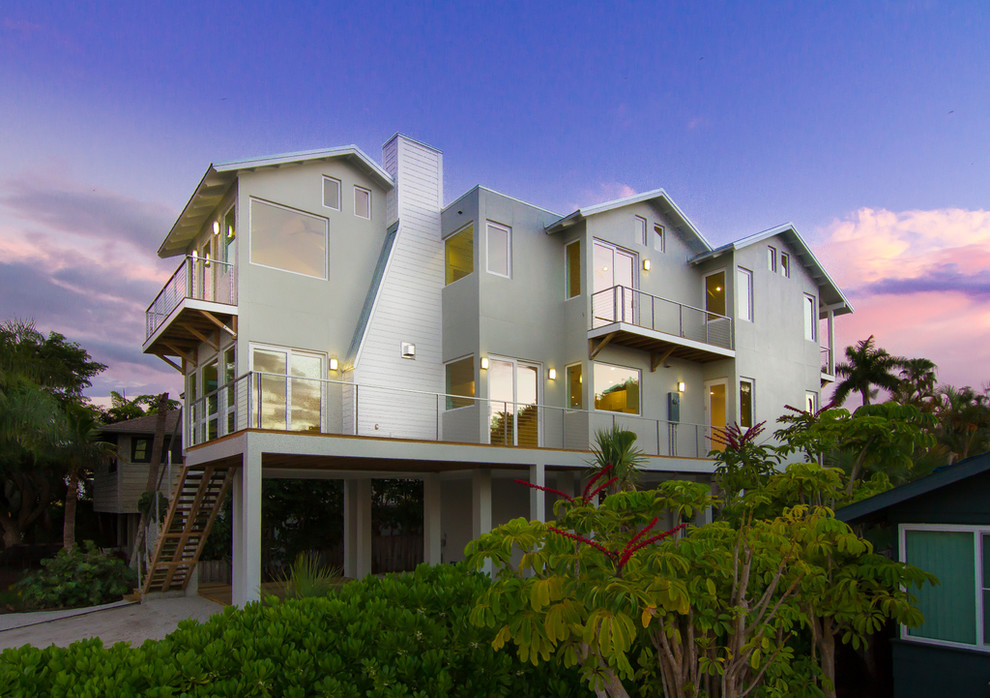 Свежая идея для дизайна: двухэтажный, серый дом среднего размера в современном стиле с комбинированной облицовкой и двускатной крышей - отличное фото интерьера
