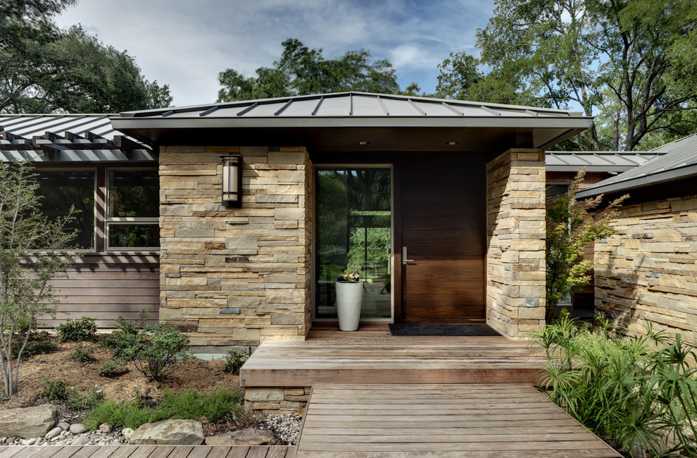 Trendy stone exterior home photo in Dallas with a metal roof