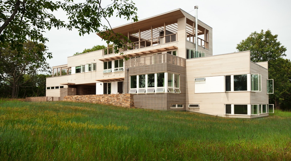 На фото: большой, трехэтажный, деревянный, бежевый дом в современном стиле с плоской крышей с