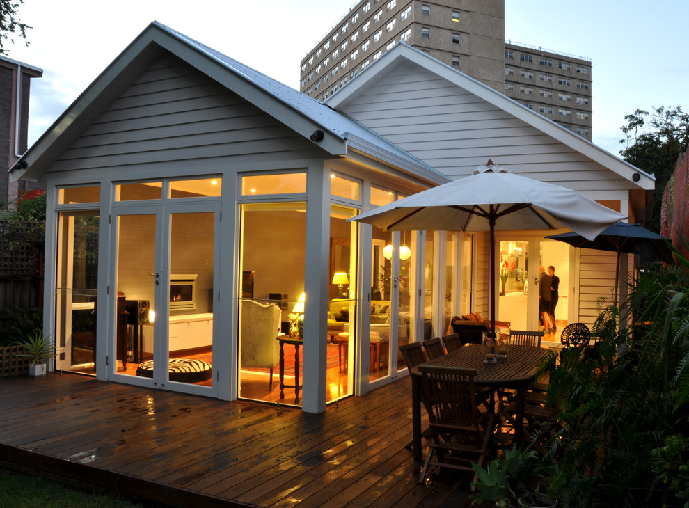 Diseño de fachada blanca moderna de tamaño medio con revestimiento de madera, tejado a dos aguas y tejado de metal