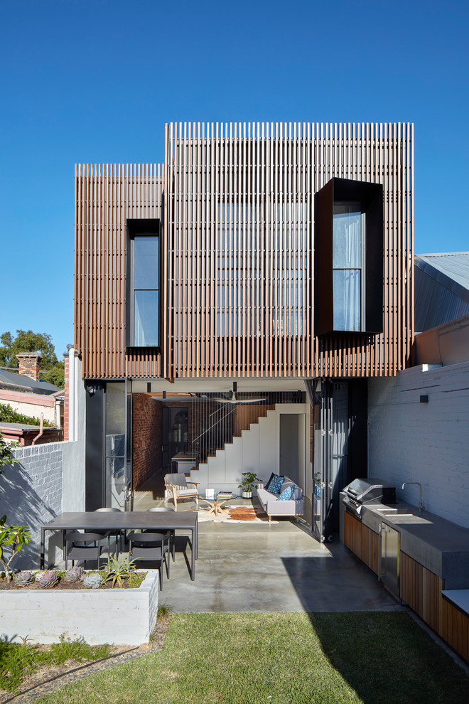 Modelo de fachada de casa pareada marrón contemporánea pequeña de dos plantas con revestimiento de madera y tejado plano