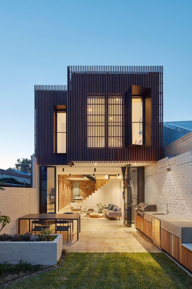 Idée de décoration pour une petite façade de maison multicolore design à un étage avec un revêtement mixte et un toit plat.