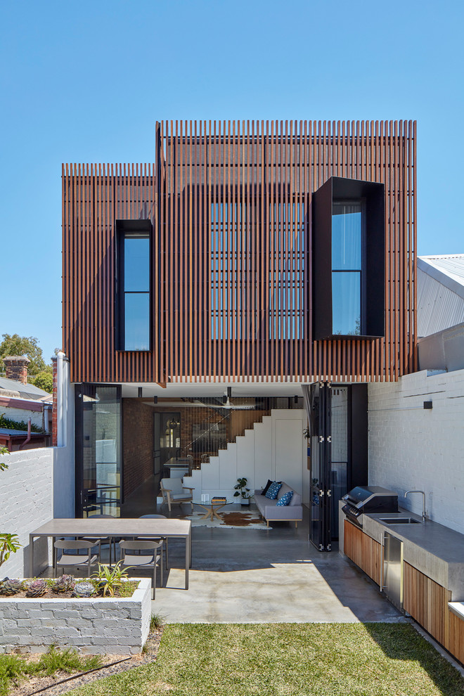 Inspiration för små moderna bruna hus, med två våningar, platt tak och tak i metall