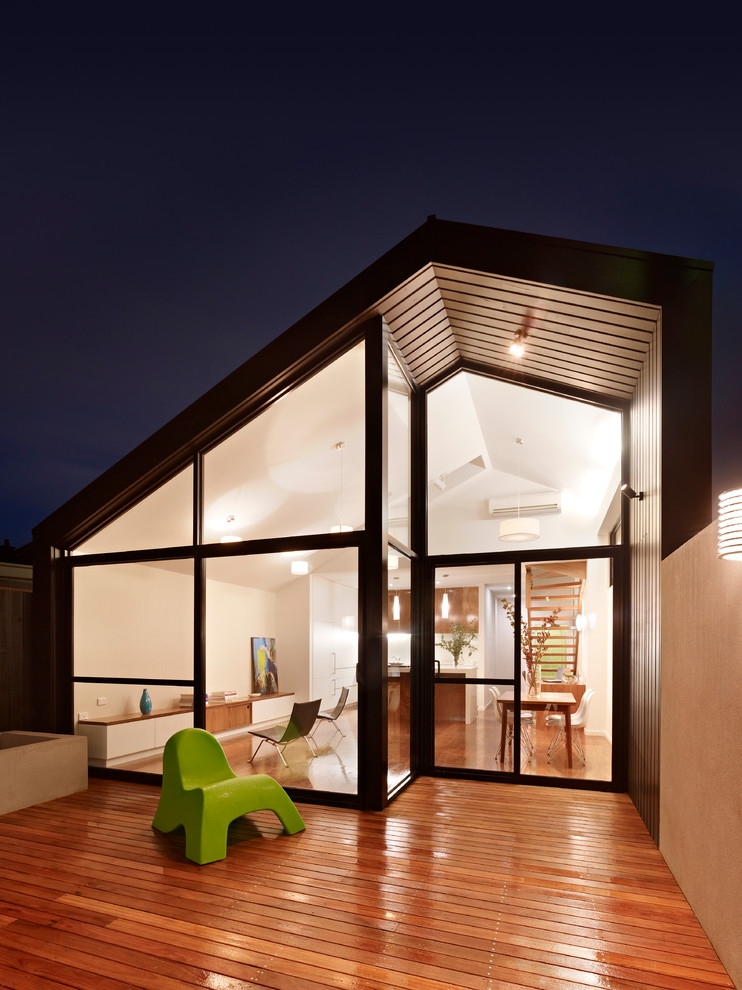 Cette photo montre une petite façade de maison noire moderne en bois à un étage avec un toit à deux pans.