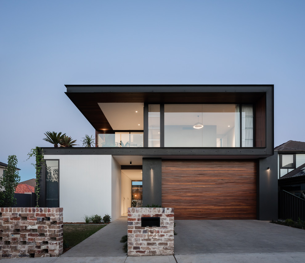 Aménagement d'une façade de maison multicolore contemporaine à un étage avec un revêtement mixte et un toit plat.